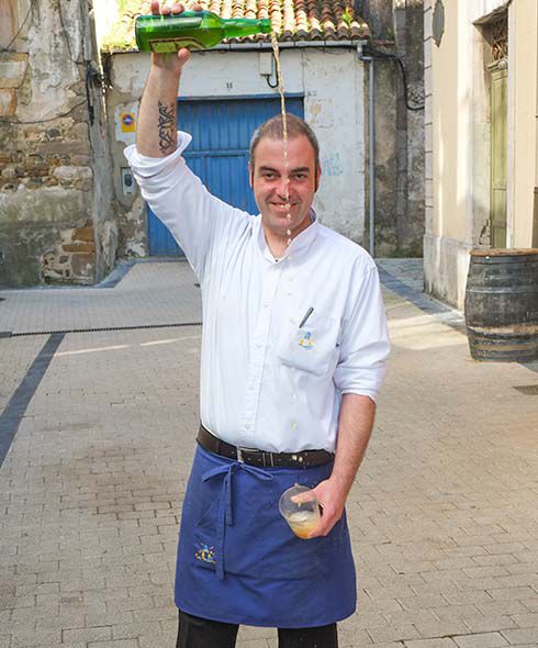 A waiter pours the cider from height in Santander 